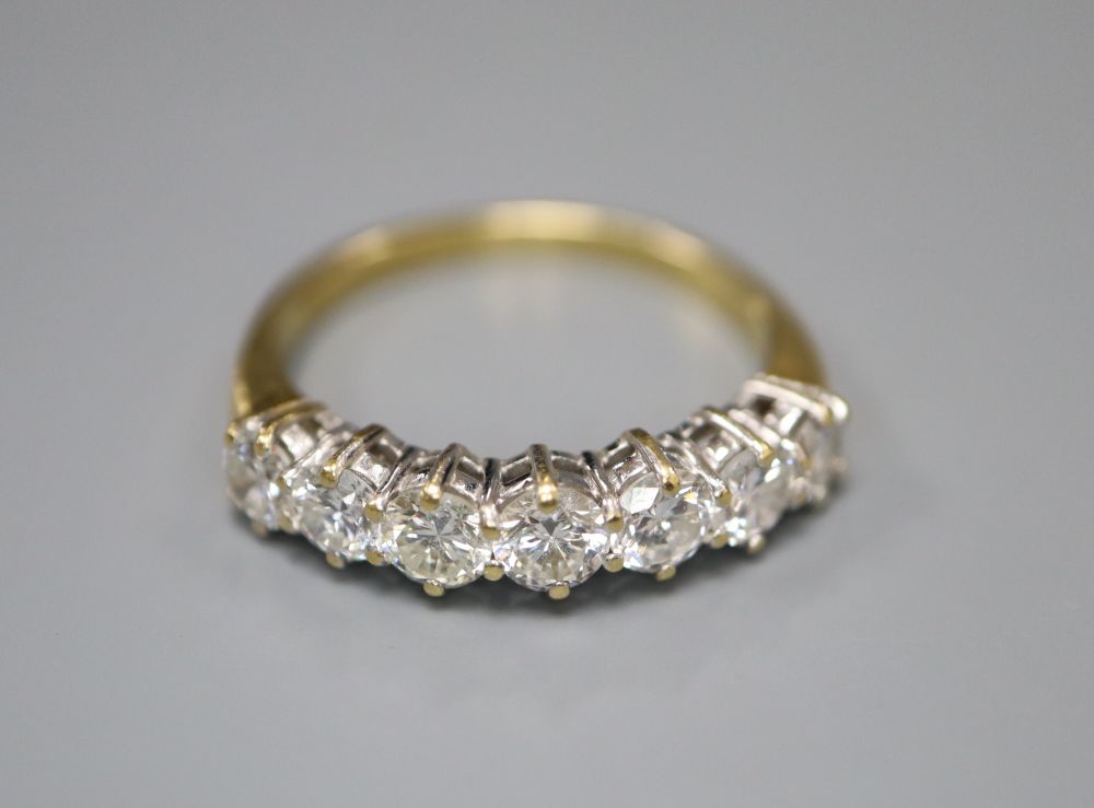 A modern 18ct gold and graduated seven stone diamond half hoop ring, size P, gross 3.6 grams.
